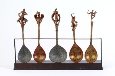 Decorative spoon depicting a naked woman standing between two scrolled arabesques