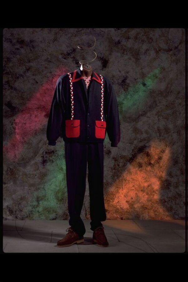 The Duffer of St George outfit: black wool cardigan with red patch pockets and white braid, red knitted T-shirt at the neck, black wool trousers, brown suede shoes