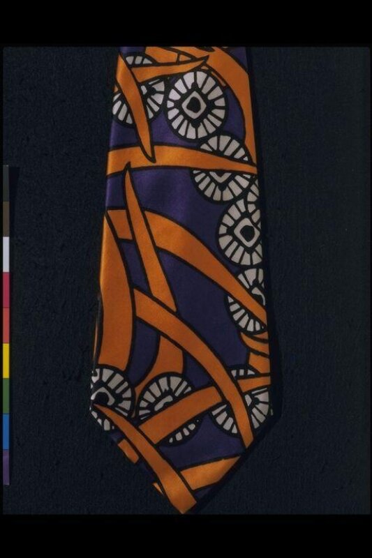 A wide printed silk tie in purple, orange and white with a bold abstract pattern