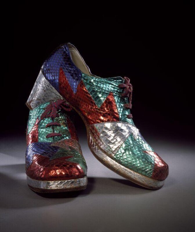 A pair of mens platform shoes in multicoloured metallic snakeskin with thick soles