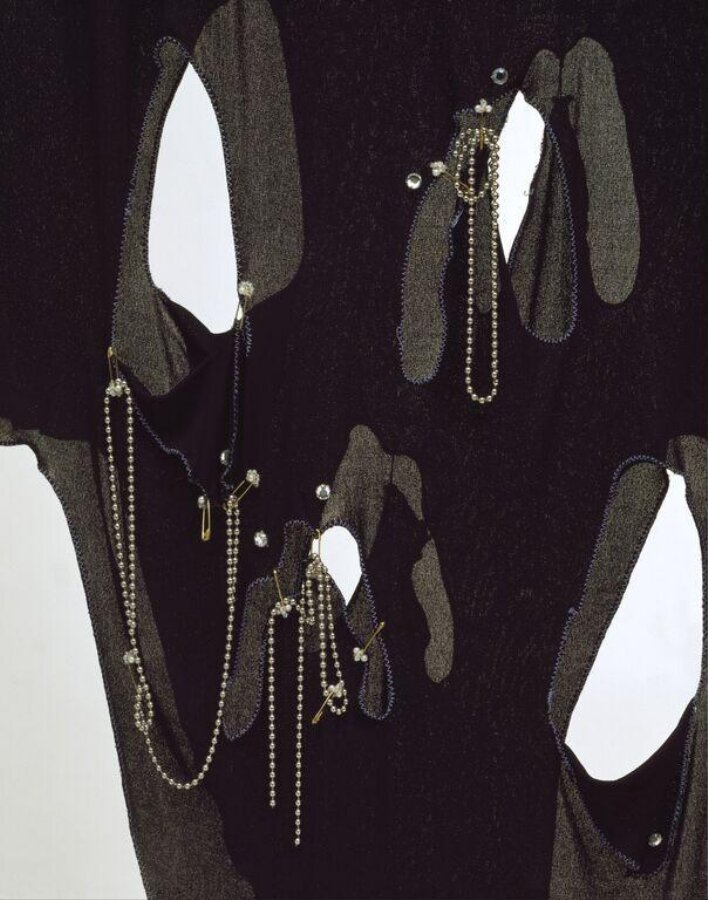 Close view of the Conceptual Chic dress: slashes edged in blue zigzag stitching, beaded safety pins and ball chains