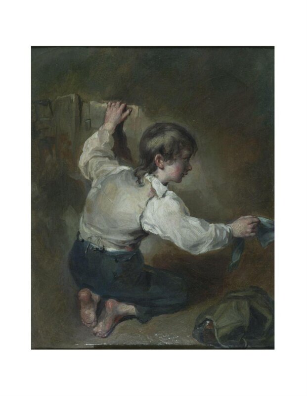 A kneeling boy with a sash