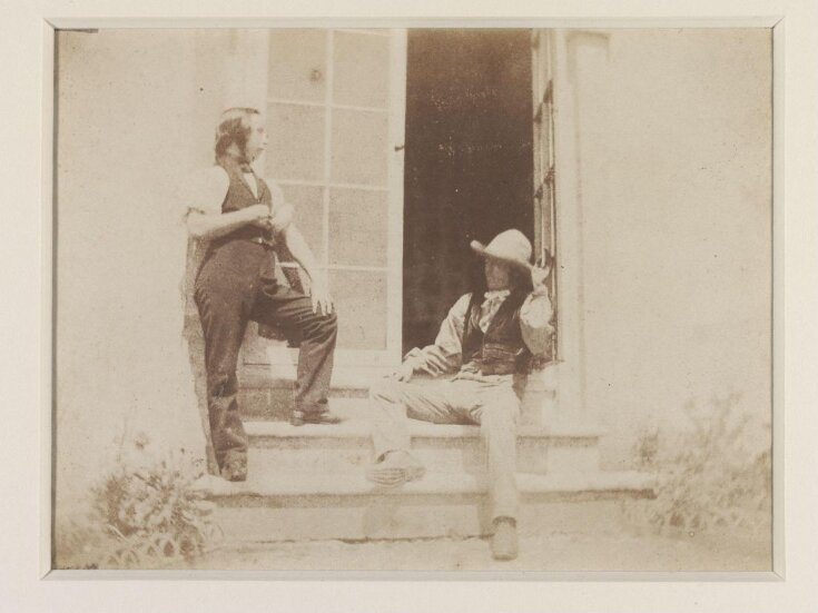 Two men in a doorway with steps top image