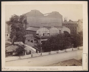 South Kensington Museum, remains of the 'Brompton Boilers', south of the Cast Courts, under demolition with Secretariat block on left, the Cast Courts in background and tower of Holy Trinity Church in distance