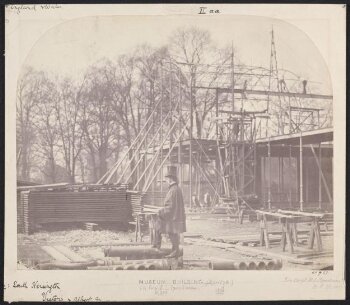 Exterior view of the South Kensington Museum (the 'Brompton Boilers') under construction with B.L. Spackman in the foreground [?]