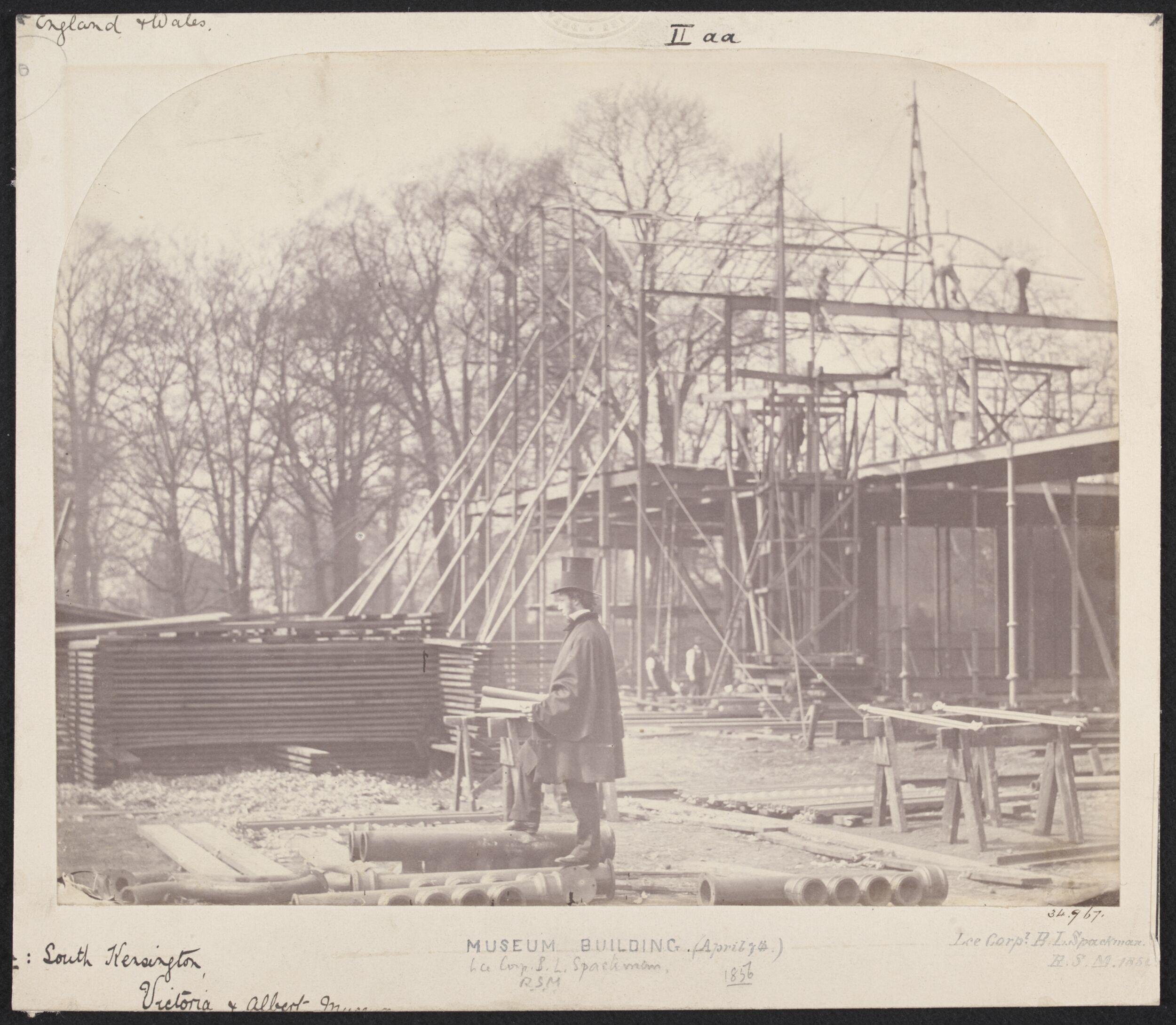 Exterior view of the South Kensington Museum (the 'Brompton Boilers') under construction with B.L. Spackman in the foreground [?]