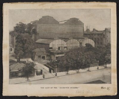 South Kensington Museum, remains of the 'Brompton Boilers', south of the Cast Courts, under demolition with Secretariat block on left, the Cast Courts in background and tower of Holy Trinity Church in distance