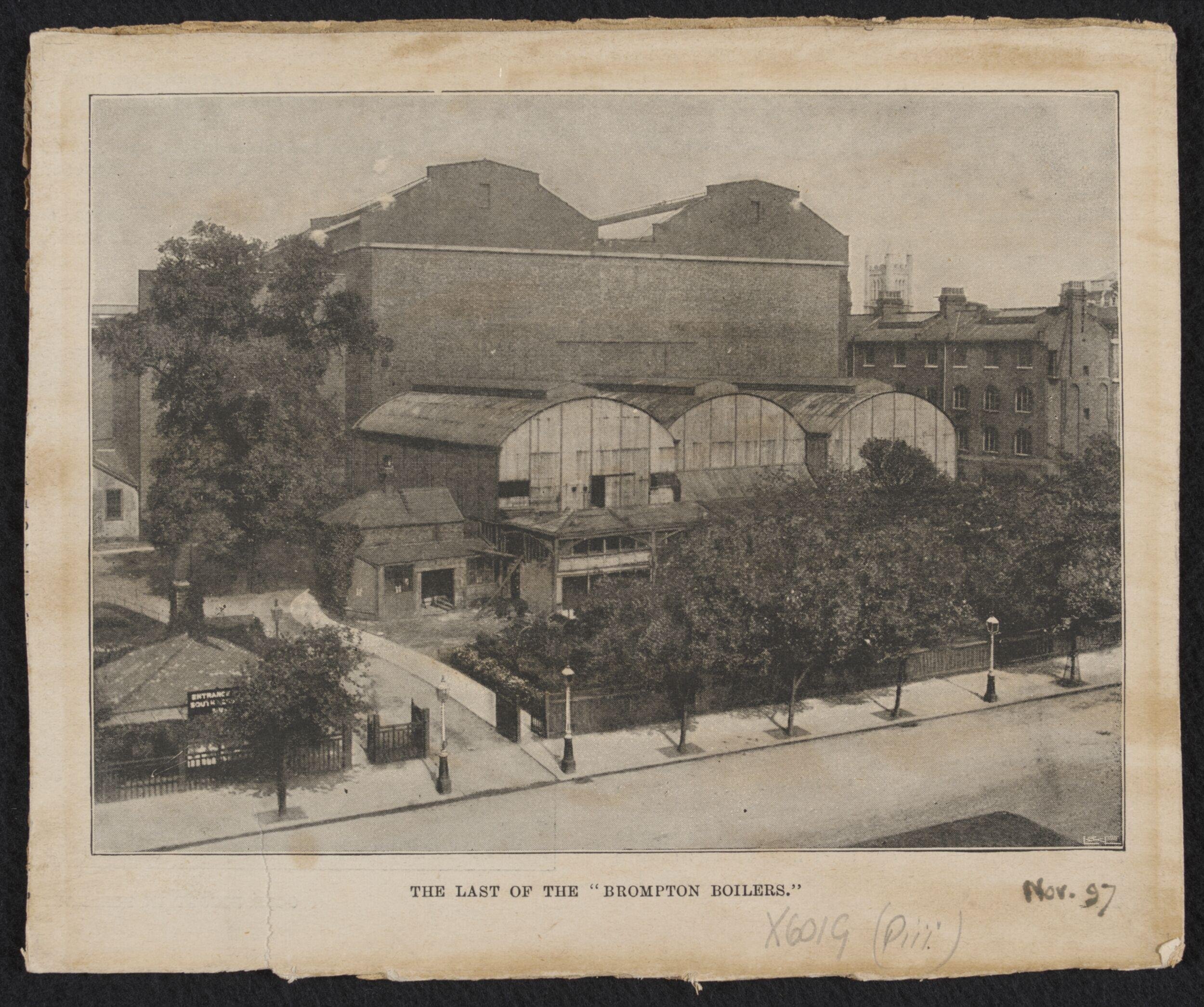 South Kensington Museum, remains of the 'Brompton Boilers', south of the Cast Courts, under demolition with Secretariat block on left, the Cast Courts in background and tower of Holy Trinity Church in distance