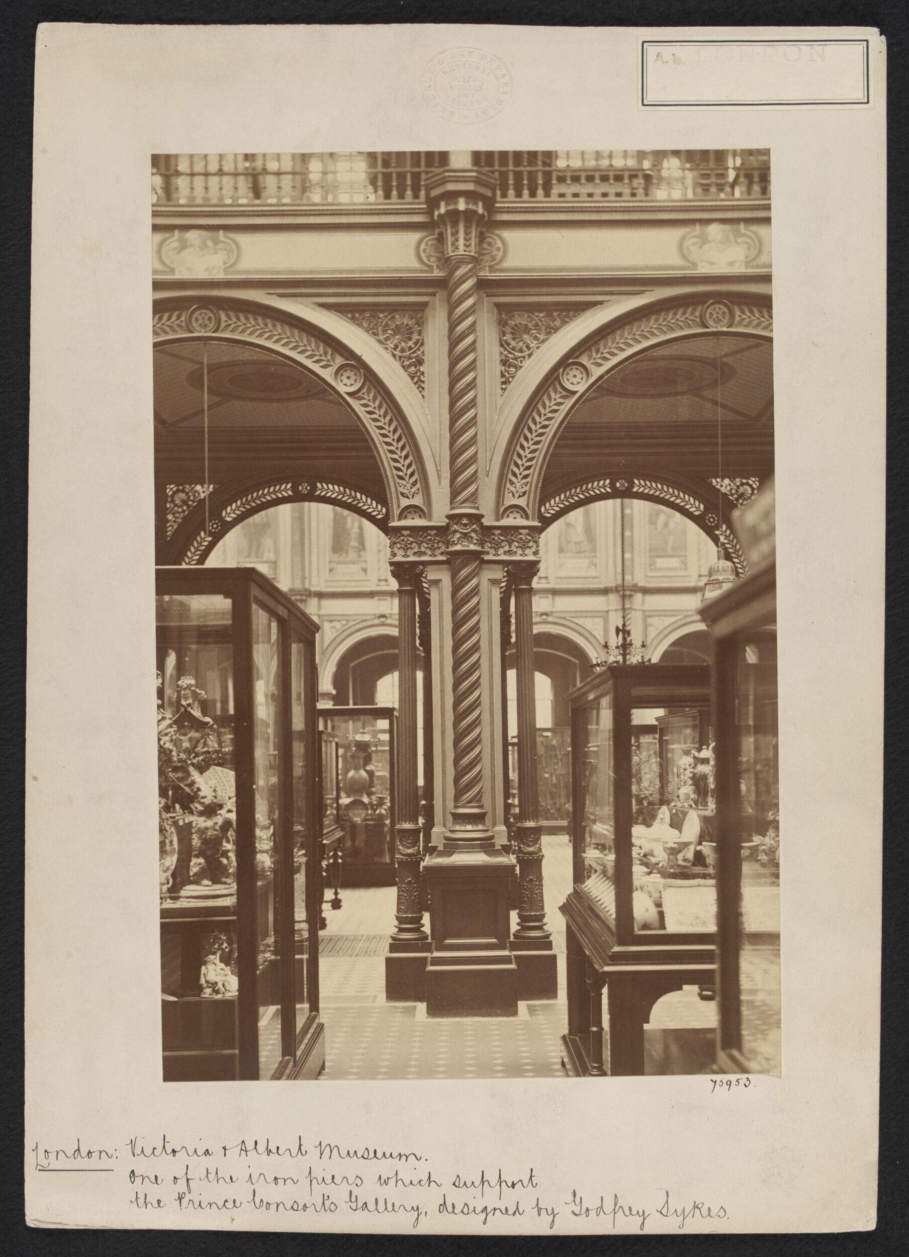 South Kensington Museum, Interior view of South Court, looking eastward from Gallery 38 into Gallery 39, showing display cases in foreground and columns supporting Prince Consort Gallery