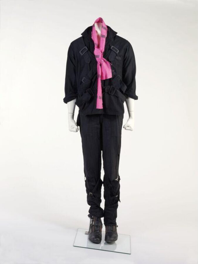 The six-part Seditionaries ensemble on a mannequin, all black except a cerise scarf