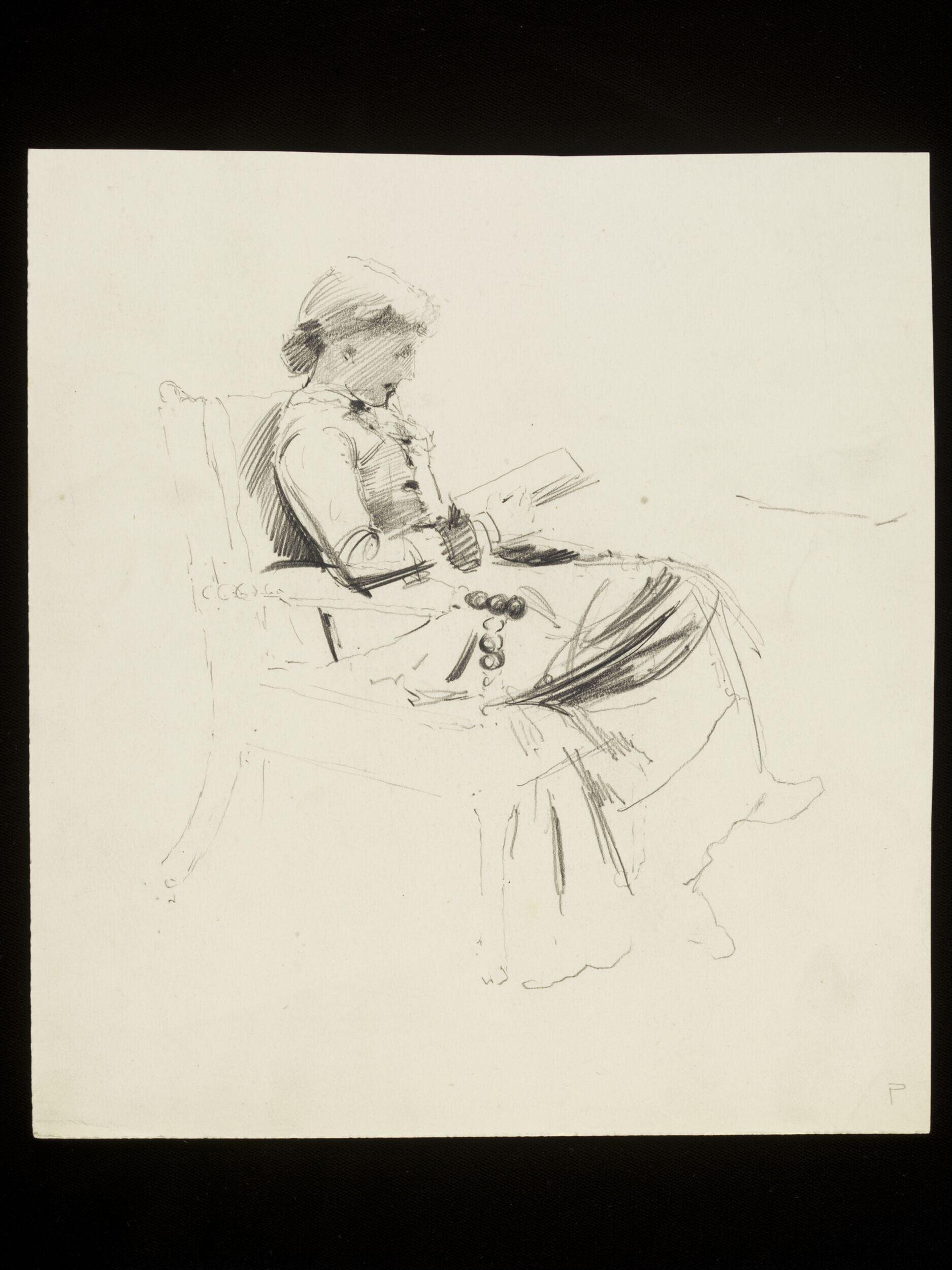 A woman seated in a chair reading a book