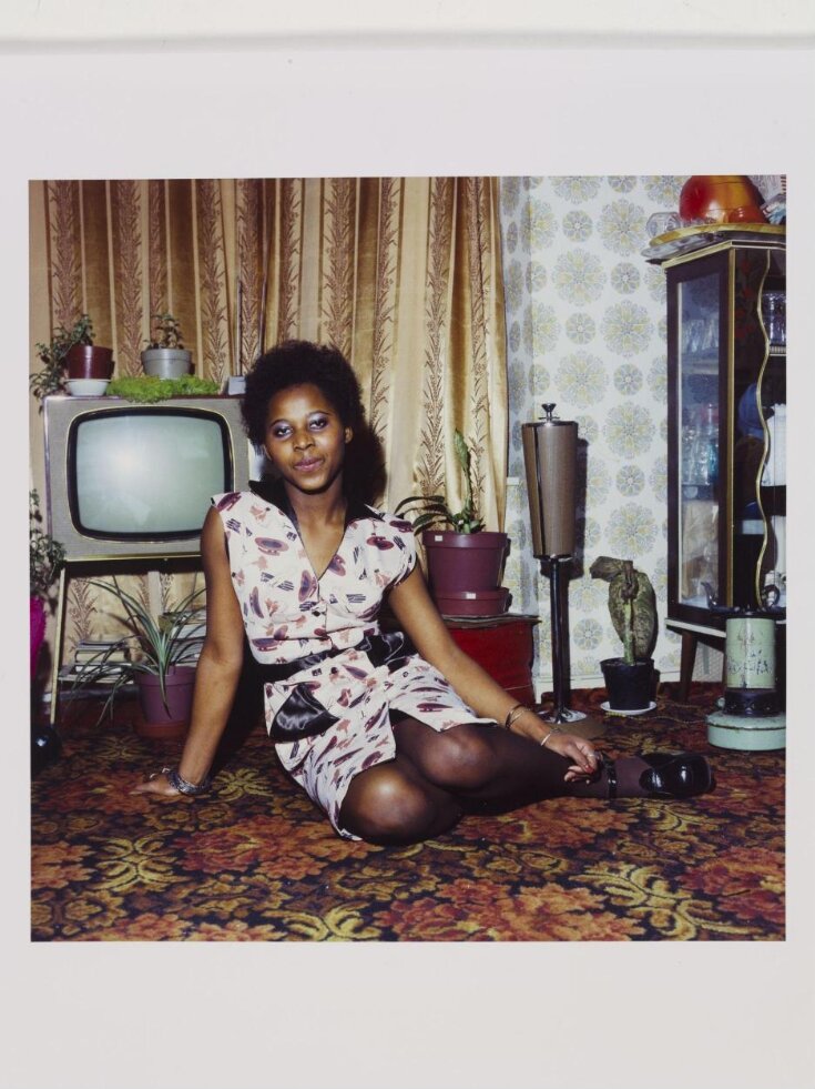 Untitled [Young woman seated on the floor at home in front of her television set] top image