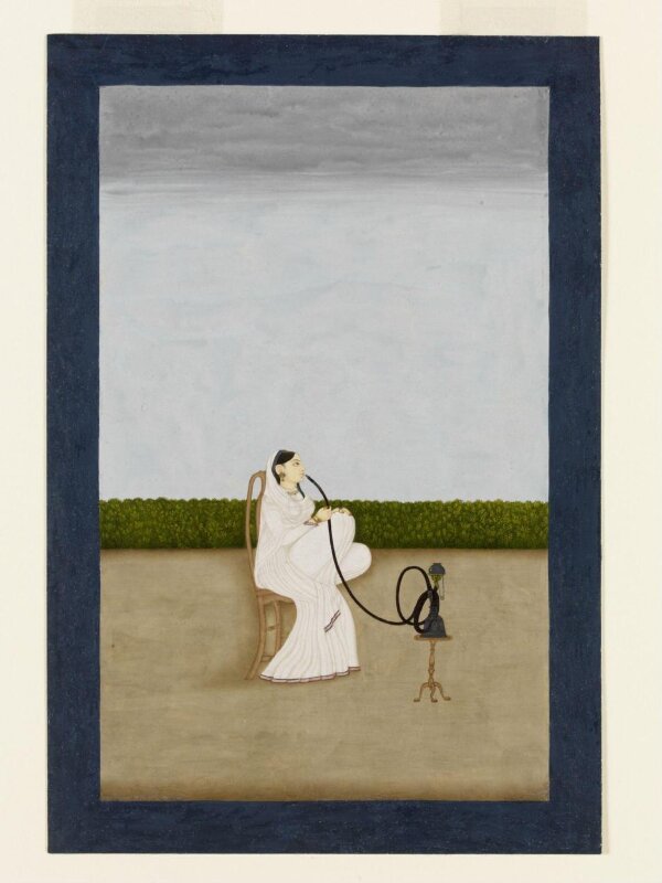A seated woman smoking a huqqa
