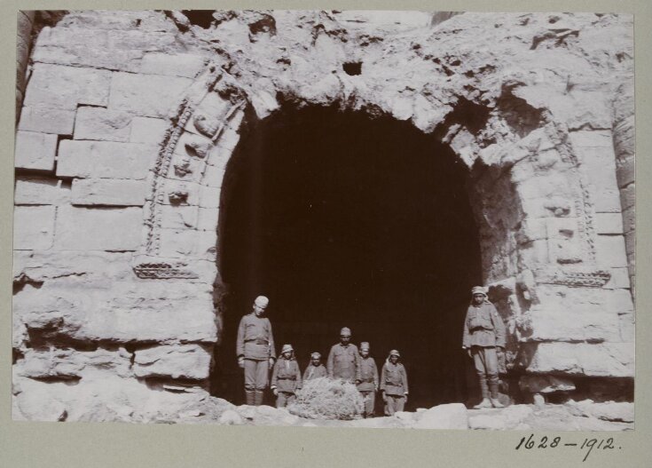 A group of seven uniformed soldiers standing in the arched entrance to Room 9 in the ruins of the Great Iwan at Hatra, Iraq top image