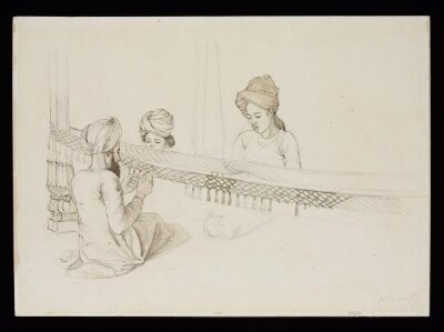 Three boys making a fringe for an elephant decoration