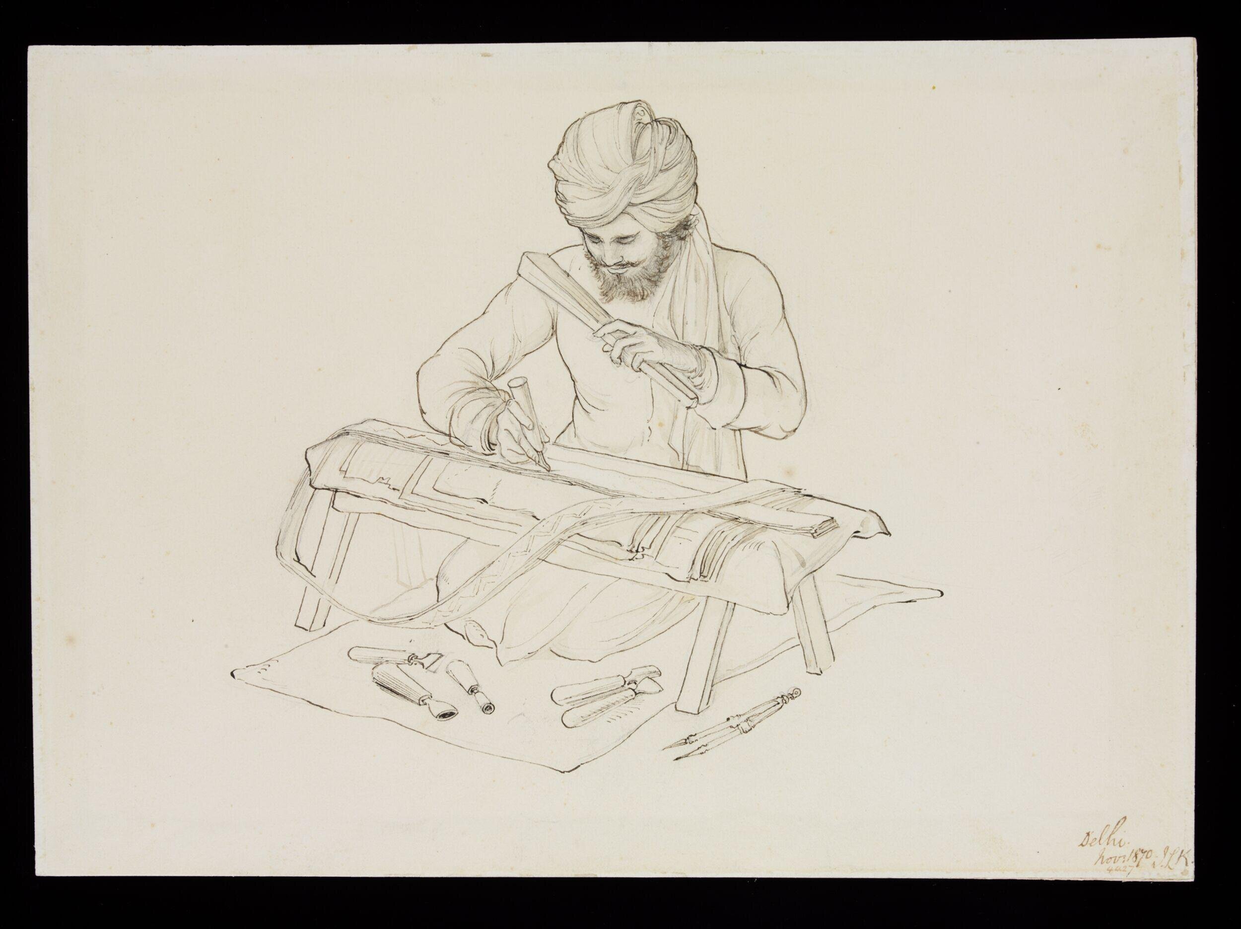 A man stamping a gold and silver lace design on a small trestle