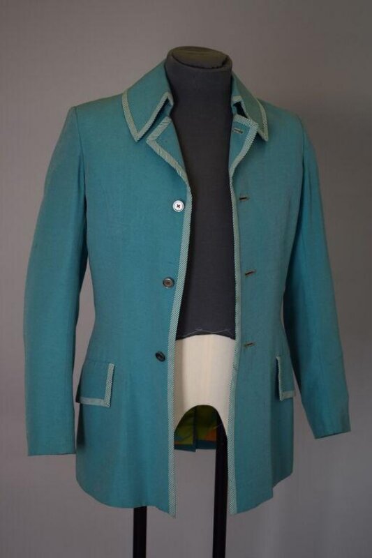A turquoise single-breasted jacket with contrast binding on the collar, lapels and pocket flaps