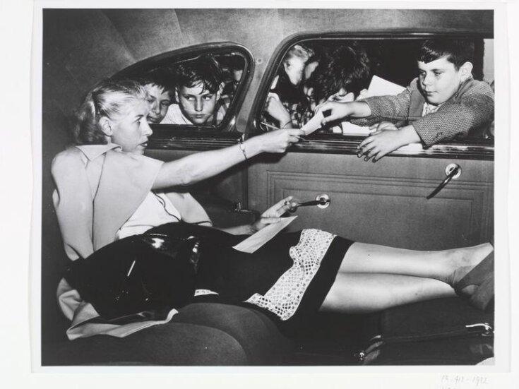 Woman signing autographs in car top image