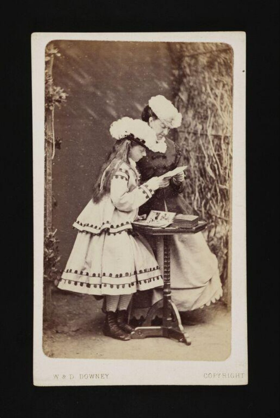 W. & D. Downey, Woman and child viewing photo albums