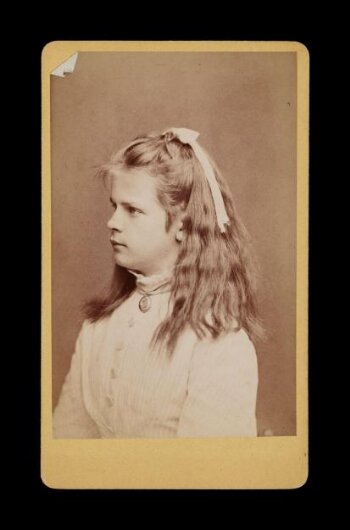 Side profile portrait of a young woman with a bow in her hair