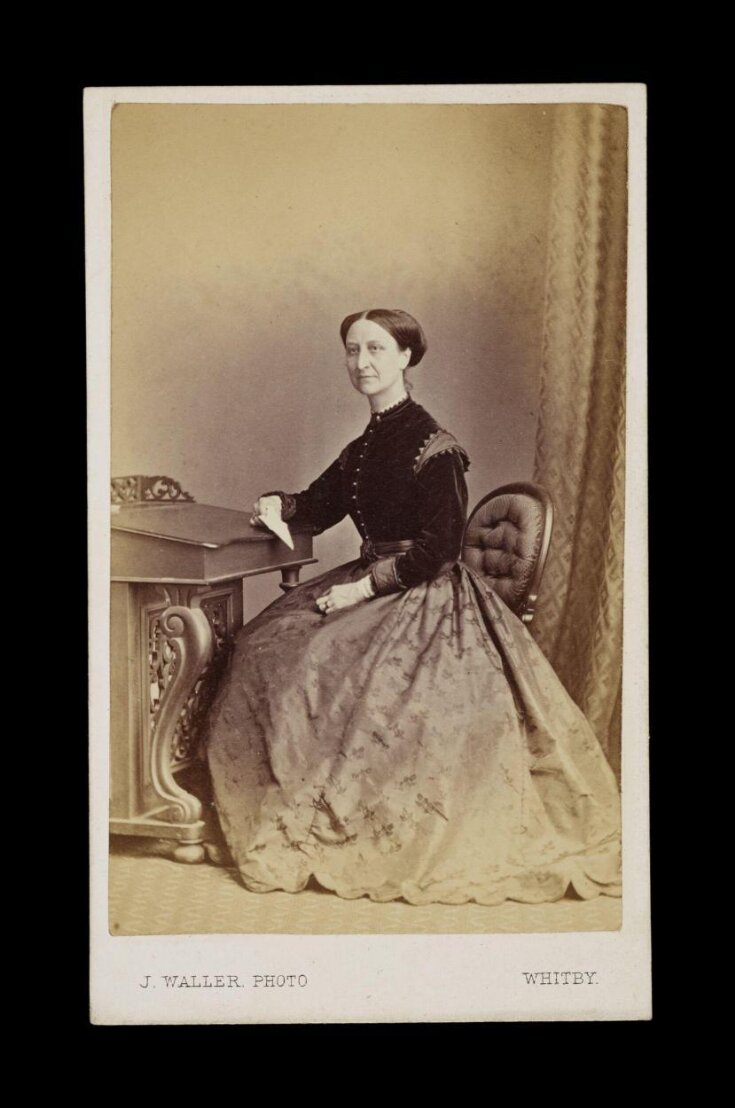 A portrait of a woman 'E. Brodrick' top image