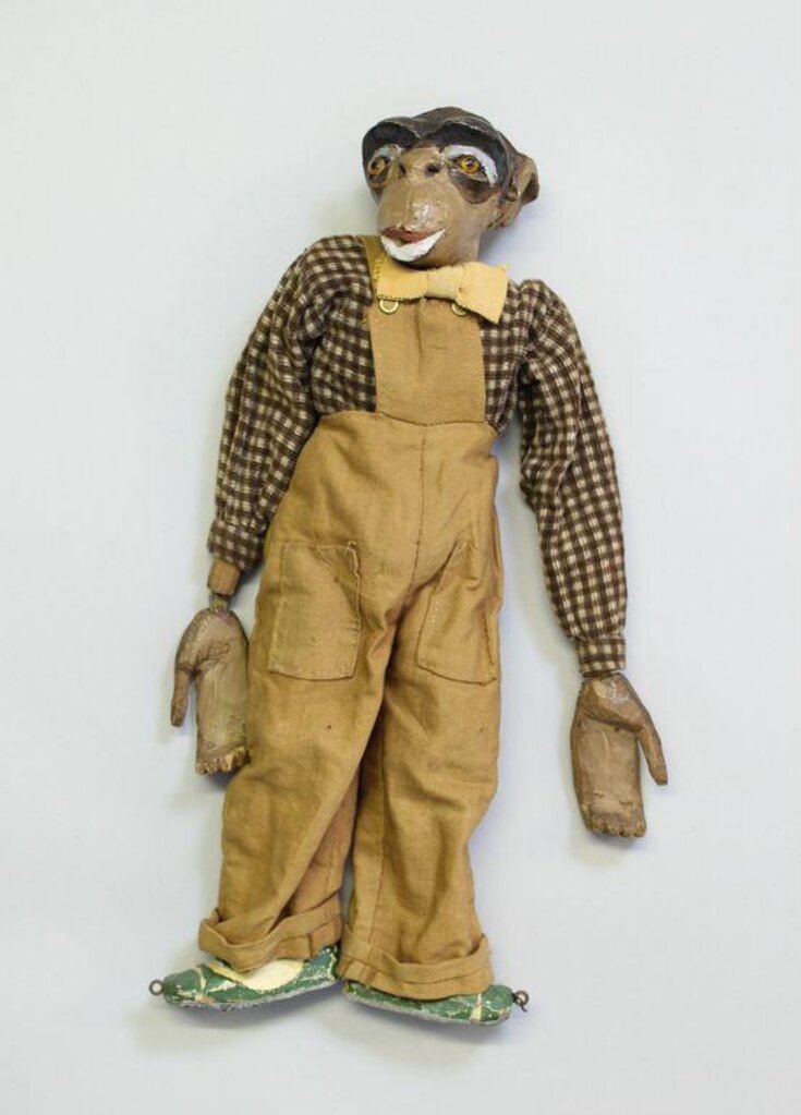 Marionette of a monkey wearing dungarees top image