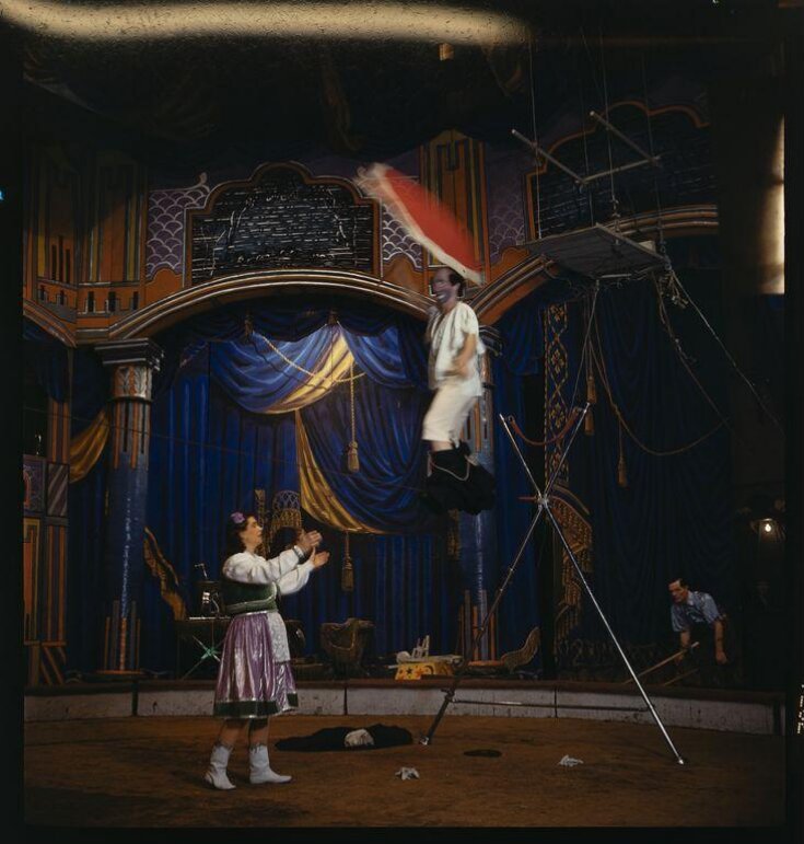 Clown performing on a tightrope top image