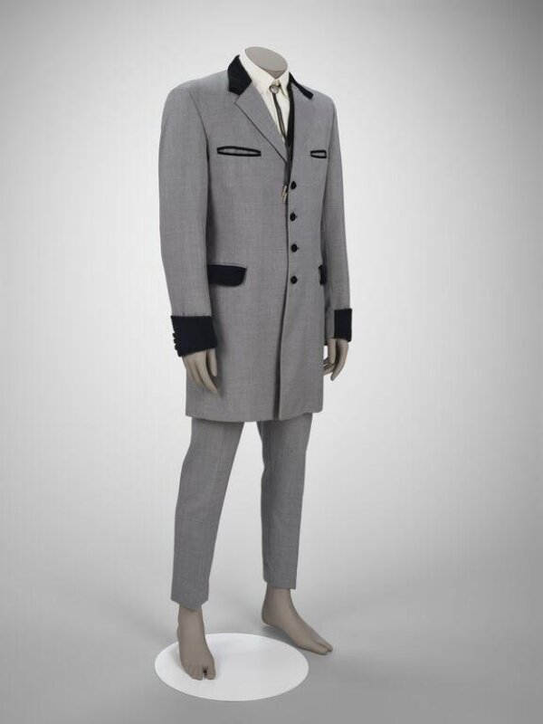 A grey worsted three-piece suit with a long jacket, black velvet collar and cuffs, and narrow trousers