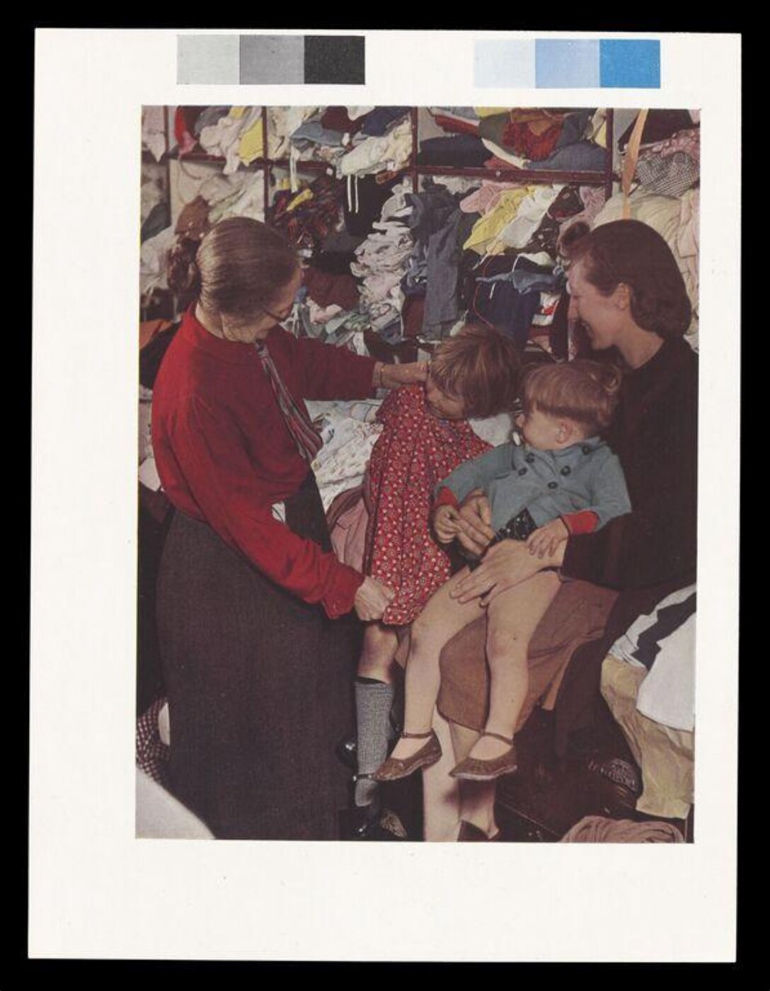 Hinde, John Wilfrid, A W.V.S. Worker Selecting a Frock for a Little Girl