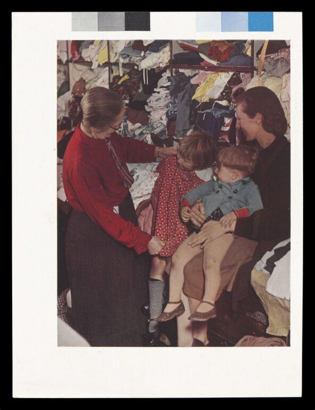 Hinde, John Wilfrid, A W.V.S. Worker Selecting a Frock for a Little Girl