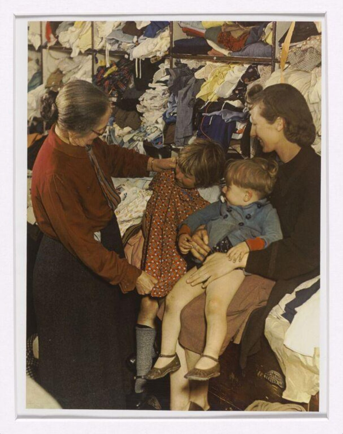 Hinde, John Wilfrid, A W.V.S. Worker Selecting a Frock for a Little Girl
